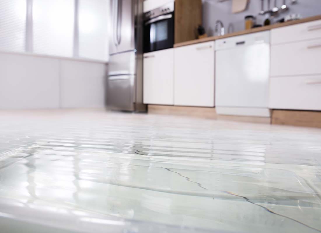 Flood Insurance - Close-up View Looking Up From a Flooded Wet Floor in a Modern Kitchen With Background Blurred