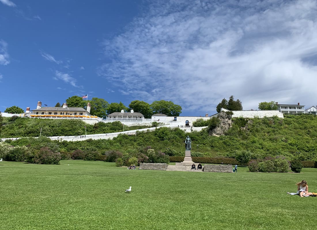 Coverage for Island Locations - Grassy Field With Buildings in Hillside and Blue Sky